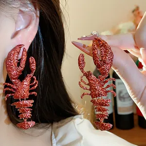 Detailed view of red textured lobster earrings with extravagant artistic design