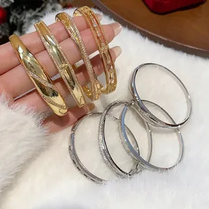 Elegante gold- und silberbeschichtete Zirkon-Armreifen mit minimalistischem Design auf Fell.