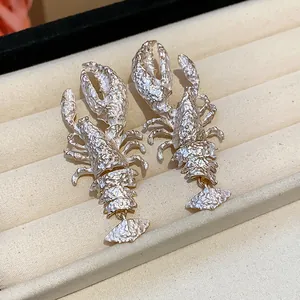 Detailed view of silver textured lobster-shaped statement earrings in a jewelry box display