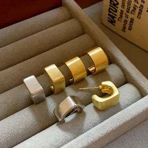 Vista detallada de pendientes de botón cuadrados geométricos cepillados en oro y plata