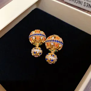 Nahaufnahme der Vintage-Ohrringe, vergoldet mit bunten Zirkonia-Steinen in einer Box.