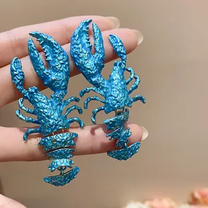 Close-up of large blue lobster earrings with textured paint finish
