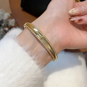 Elegante Nahaufnahme eines vergoldeten Armreifs mit Zirkon-Hulu-Design an einem Damenhandgelenk