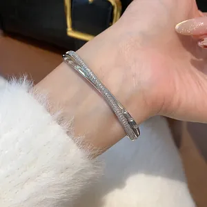Nahaufnahme eines eleganten silberfarbenen Armreifs mit Zirkonia-Besatz am Handgelenk