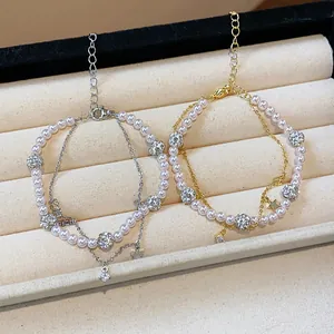 Close-up detail showing two double-layered bracelets with pearls, stars, and zircon balls.