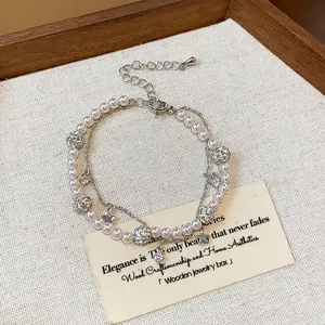 Detailed view of the double-layer pearl bracelet featuring zircon stars and elegant charms