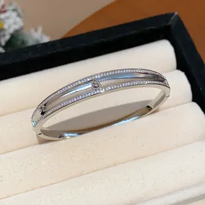 Detailansicht des silberfarbenen Armbands mit Zirkonia-Hulu auf einem beigen Samtständer.