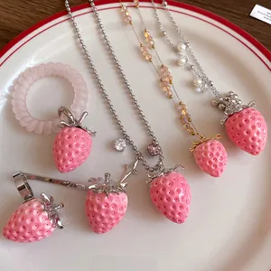 Close-up of sweet pink resin strawberry pendant necklaces and hair accessories