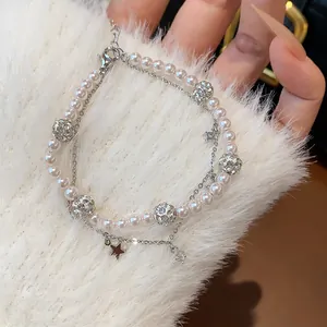 Close-up detail of double-layer bracelet with pearls, zircon beads, and star charm