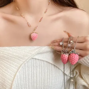 Detailed close-up view of cute pink resin strawberry pendants on stainless steel necklaces