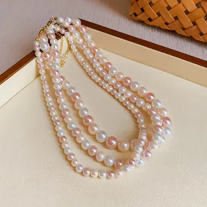Close-up of elegant multi-layered white and pink pearl necklace displayed on a tray