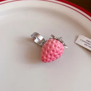 Detailed close-up view of a sweet pink resin strawberry ring with stainless steel band