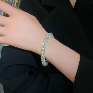 Close-up of a sparkling rhinestone geometric bracelet worn on a wrist with black suit.
