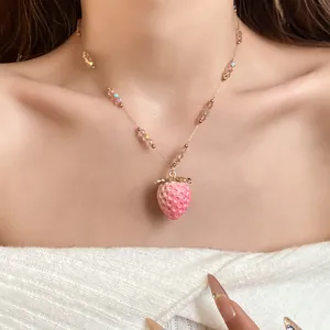Detail of sweet strawberry pendant necklace with pink resin fruit and iridescent beads
