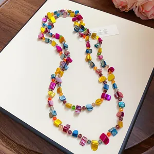 Detailed view of a bohemian multi-layered colorful crystal and shell beaded necklace style