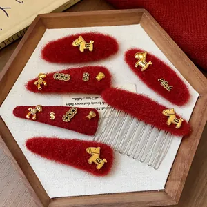 Dettaglio delle mollette per capelli in lana rossa con ciondoli a forma di cavallo