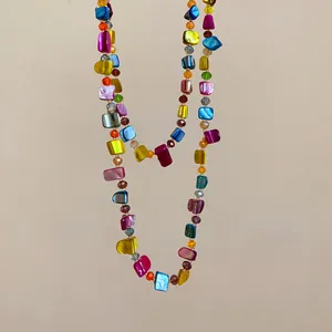 Close-up detail of a colorful bohemian beaded necklace featuring irregular shell pieces