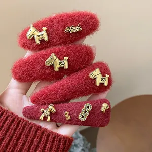 Vista dettagliata di fermagli per capelli in lana rossa con ciondoli a forma di cavallo
