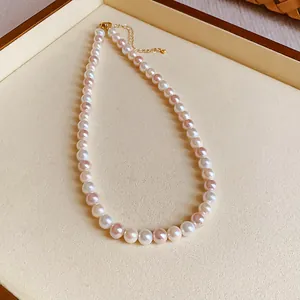 Detailed view of elegant necklace featuring alternating white and pink pearls on a tray