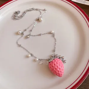 Close-up of cute pink resin strawberry pendant on stainless steel chain with pearls