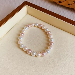 Close-up of elegant elastic bracelet with alternating white and pink pearls in a tray