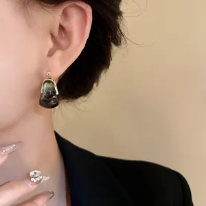 Detailed close-up view of vintage U-shaped basket earrings with marble ink pattern