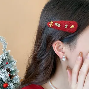 Primo piano di un fermaglio per capelli in lana rossa con ciondoli d'oro festivi