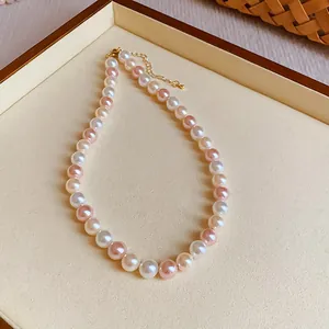 Close-up of elegant pink and white pearl necklace on a cream jewelry tray