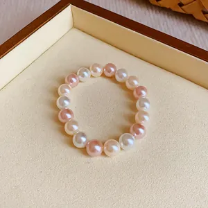Detailed close-up of a sweet elastic pearl bracelet with mixed pink and white beads.