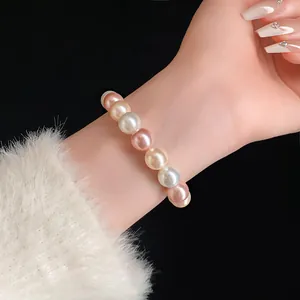 Close-up of an elegant multi-colored pearl elastic bracelet worn on a woman's wrist.