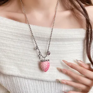 Detail of sweet pink resin strawberry pendant necklace on a stainless steel ball chain