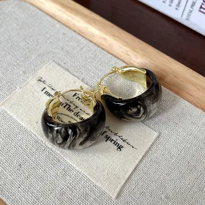 Detailed view of vintage U-shaped hoop earrings featuring smoky ink marble resin