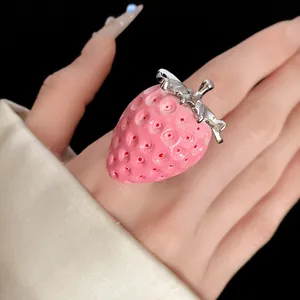Detailed macro shot of a realistic pink resin strawberry pendant with silver metal top