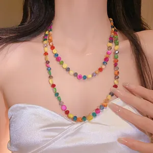 Detail of a Bohemian colorful crystal multi-layer beaded necklace on a model's neck.