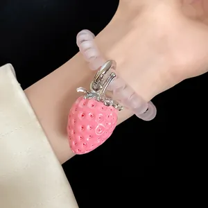 Detailed macro view of a pink resin strawberry pendant attached to a frosted spiral band
