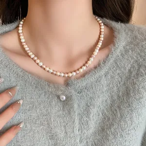 Detailed close-up of an elegant multicolor pearl necklace worn by a female model