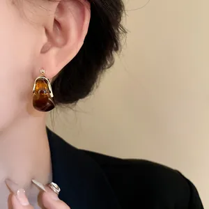 Vintage U-shaped basket earrings with amber marbled resin detail on model
