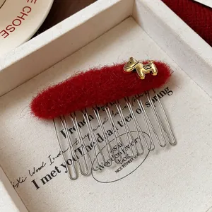 Primo piano di un pettine per capelli in feltro rosso con charm a forma di pony