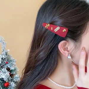Primo piano di un fermaglio per capelli festivo in lana rossa con ciondoli dorati