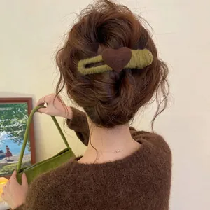Detailansicht einer herbstlichen Woll-Haarklammer mit einem weichen braunen Herzmotiv