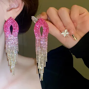 Dettaglio di orecchini a nappa con strass rosa sfumati e design pendente di lusso.