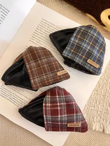 Detailed view of three retro plaid and leather shark hair clips on an open book background