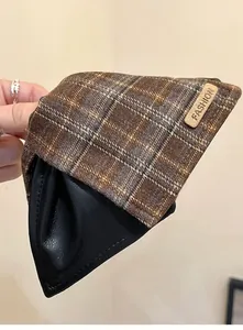 Close-up detail of vintage brown plaid and black leather hair claw clip texture