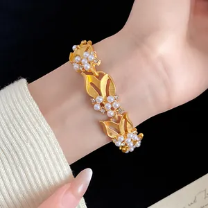 Detailansicht eines goldenen Weizenähren-Armbands mit Perlen und funkelnden Zirkonen