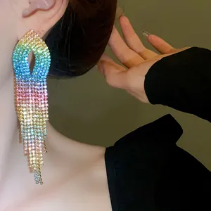 Vista dettagliata dell'orecchino a nappa con strass sfumati arcobaleno sul modello