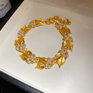 Detaillierte Nahaufnahme der goldenen Weizenähren-Halskette mit eleganten Perlen und Zirkonia