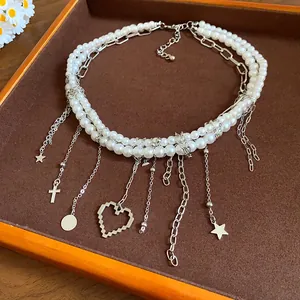 Detail view of a multi-layer pearl necklace with pixel heart and star charms.