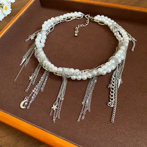 Detailed view of a handmade pearl and silver chain necklace with star and moon charms
