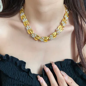 Detailansicht einer goldenen Weizenähren-Halskette mit Perlen und Zirkonia