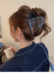 Detailed back view of a vintage plaid and leather shark clip in a stylish updo
